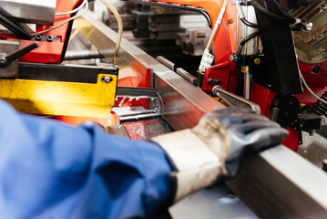 Crop worker hand on metal beam in workshop at factory