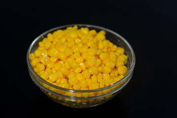 grains of canned corn are in a bowl. selective focus