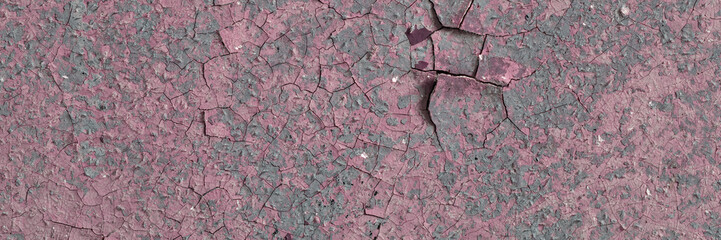 Peeling paint on the wall. Panorama of a concrete wall with old cracked flaking paint. Weathered rough painted surface with patterns of cracks and peeling. Wide panoramic grunge texture for background