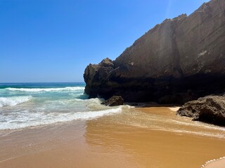 Rocky coast of the ocean bay, clear blue sky, ocean horizon, rocks