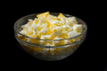 chopped chicken eggs in a bowl on a black background