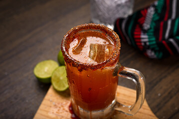 Michelada, typical mexican cocktail on a wooden table. Beer cocktail.