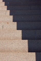 Closeup of concrete city stairs with sunlight and shadow.
