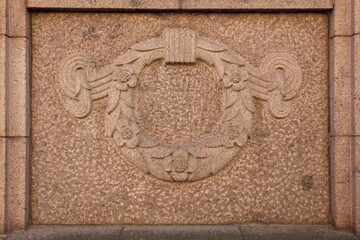 Closeup of old stone carving on the wall of a building.