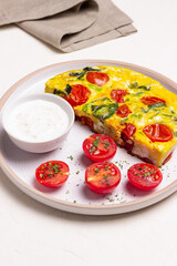 Frittata with tomatoes and spinach. Italian cuisine. Vegetarian food.
