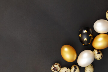 Gold, black and white Easter eggs on a dark background.