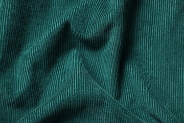 Texture of dark green crumpled fabric as background, top view