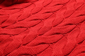 Texture of soft red knitted fabric as background, closeup