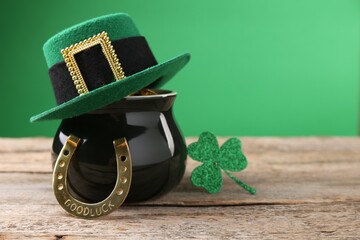 St. Patrick's day. Pot of gold with leprechaun hat, horseshoe and decorative clover leaf on wooden...