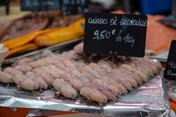 Assortment of meat on weekly food market in France, English translation: frog legs, price by 100 gr