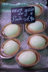 Assortment of meat on weekly food market in France, English translation: chicken eggs in jelly