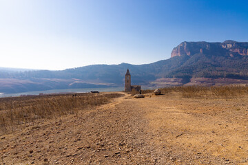 The ruins of the bell tower of the Romanesque church of Sant Roma de Sau stand out on the dry bed...