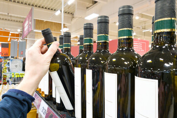 Bottle of white wine on hand in shop