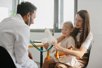 The pediatrician establishes contact, trust and a good relationship with the child. Happy little...