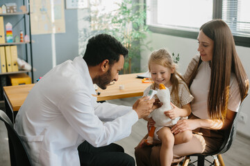The doctor plays with the child patient in order to establish contact and enter into trust.