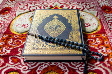 Qur'an with tasbih or rosary beads. Islamic holy book.