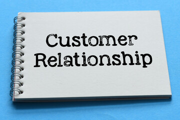 Customer relationship words in office notebook on blue table.