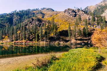 Beautiful autumn landscape with clear water lake and yellow foliage in mountains