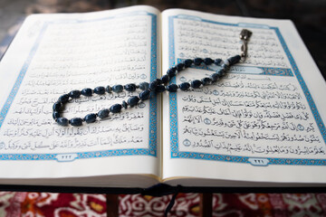 Tasbih or rosary beads over Holy Qur'an text.