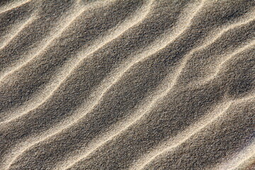 Fototapeta na wymiar Captivating Sands: The Stunning Texture Left Behind by the Sea's Gentle Caress