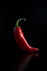Singular Red Chili Pepper on a Black Background: A Portrait of Spicy Minimalism