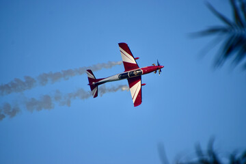 pilot clearly visible in an airshow of aerobatic planes showcasing parachutes paramotor skydiving...