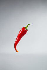 Levitating Red Chili Pepper on Neutral Background: Spice Defying Gravity