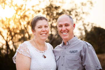 Joyful middle aged couple standing together in afternoon light - faithfulness