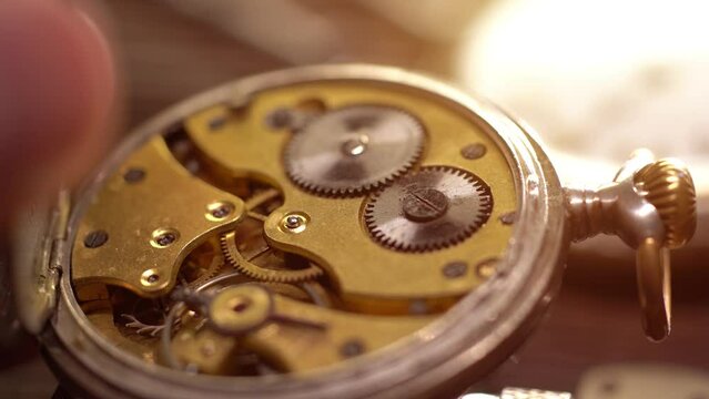 Watchmaker holds the vintage pocket watch. Mechanical watch repair. Starting the watch mechanism