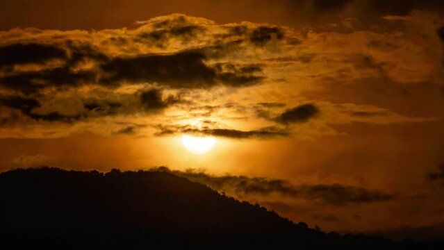 Timelapse of dramatic sunrise with orange sky in a sunny day.