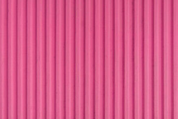 Old pink red concrete background wall with vertical line ribbed. Stripes as a texture.