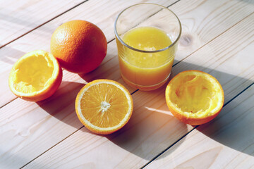  Fresh ripe  oranges  and glass of juice on wooden background   