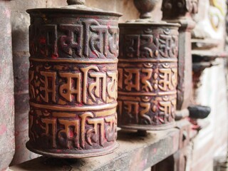 Closeup shot of traditional prayer wheels near a temple in Nepal