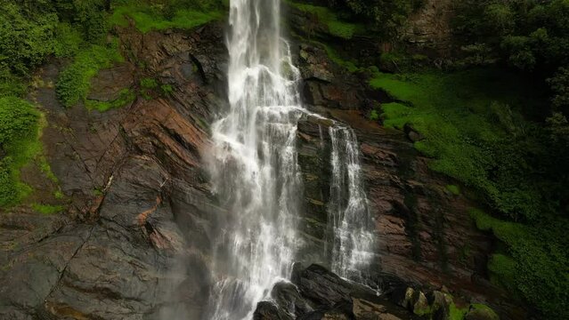 A tropical waterfall falling on the rocks. Ramboda falls in Sri Lanka close up aerial view.