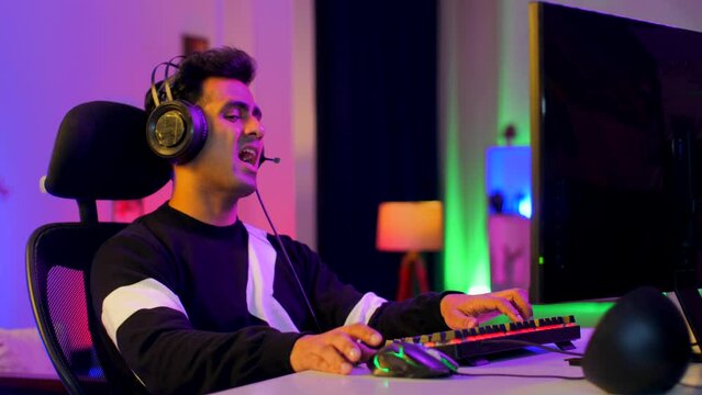 A professional Indian gamer addicted to playing online video games - interior gaming setup at home. Stressed gamer losing a match online and leaving the setup in frustration and anger - irritation ...