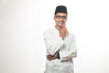 Asian Muslim man with glasses, brown skin, smiling and posing with his hand on his chin facing the...