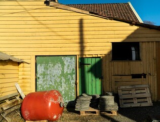 a house with a red barrel near a green door and window