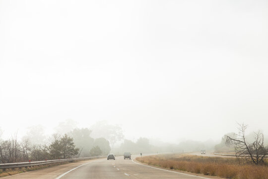 Car driving on road in hazardous condition fog