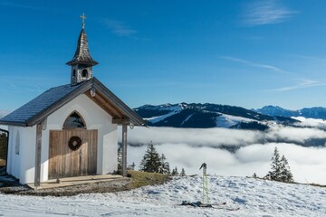 Fototapeta na wymiar Scenic view of a chapel on top of a hill covered with snow in winter in Austria
