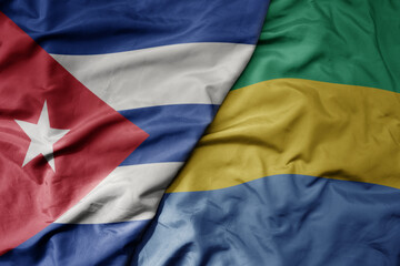 big waving national colorful flag of gabon and national flag of cuba .
