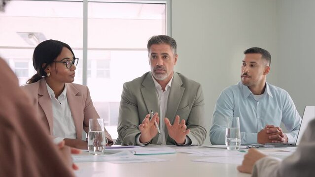 Smiling diverse executive board work group talking at office meeting. Busy diverse professional workers team consulting managing project, having discussion at corporate boardroom table.