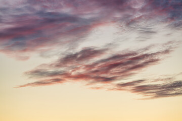 Fototapeta premium A beautiful sky tinted by the sun leaving vibrant shades of gold, pink, blue and multicolored. Clouds in the twilight evening and morning sky. Cloudy sky background in the evening and during the day.