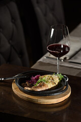 Chicken leg stuffed, served with vegetables on a black plate