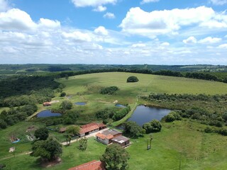 Rustic ranch surrounded by a picturesque landscape of green grass and lush trees.