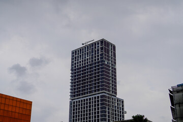Minimalist glass facade, steel framework holding the large transparent panels. Contemporary commercial architecture, vertical converging geometric lines. Blue sky reflection in the glass panels