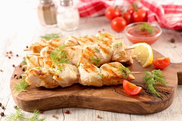 grilled chicken kebab skewers on wooden board