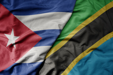 big waving national colorful flag of tanzania and national flag of cuba .