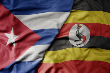 big waving national colorful flag of uganda and national flag of cuba .