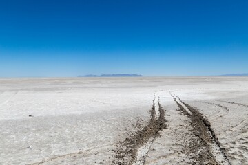 Barren dirt road winding its way through a desolate landscape of dry, rocky terrain