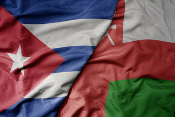 big waving national colorful flag of oman and national flag of cuba .